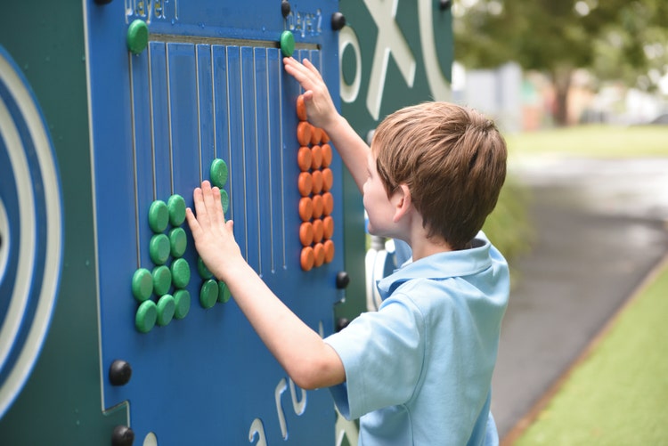 one boy playing with the abucus outdoor equipment